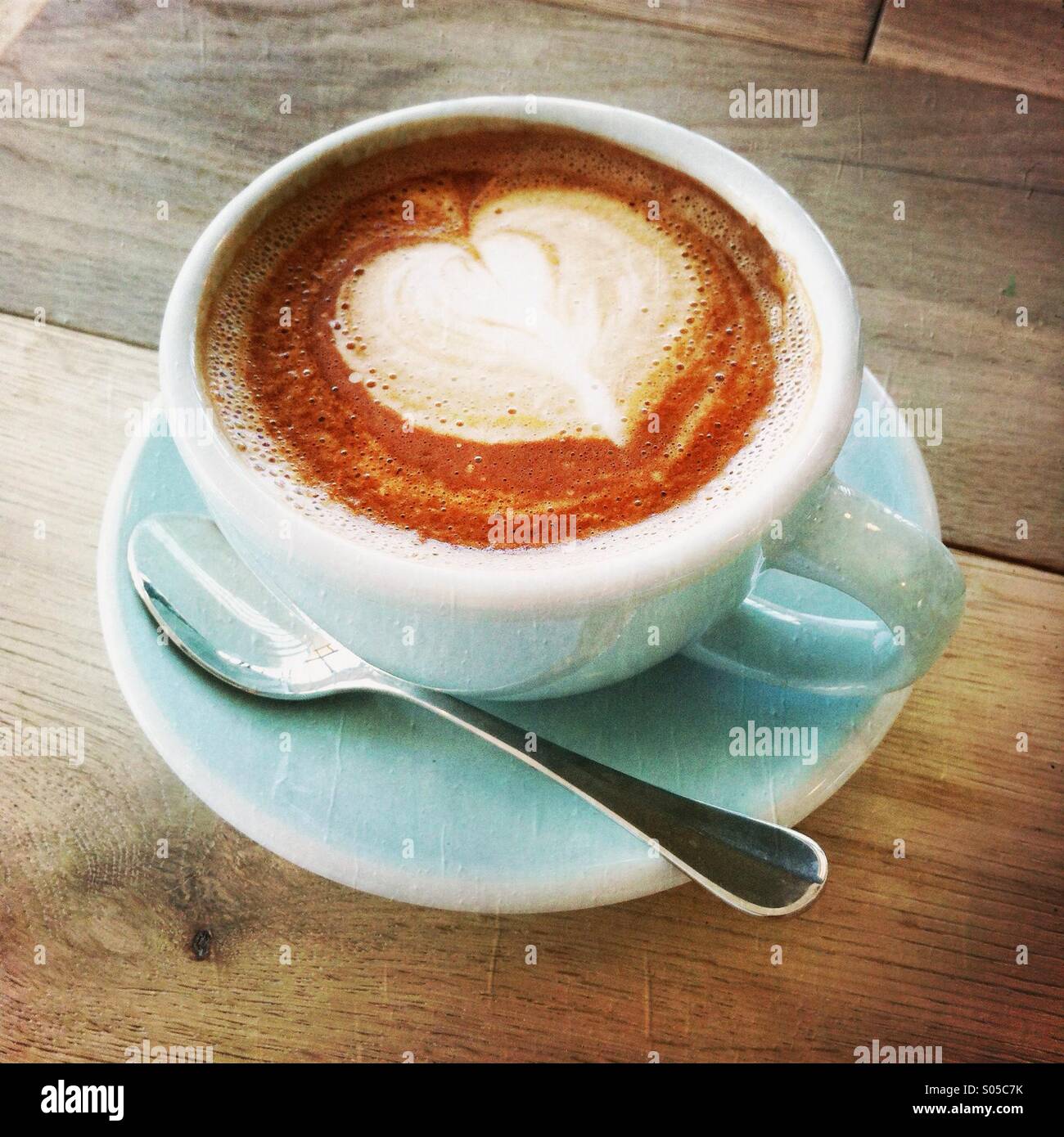 A cup of latte/cafe mocha with a heart shaped on the top. Stock Photo