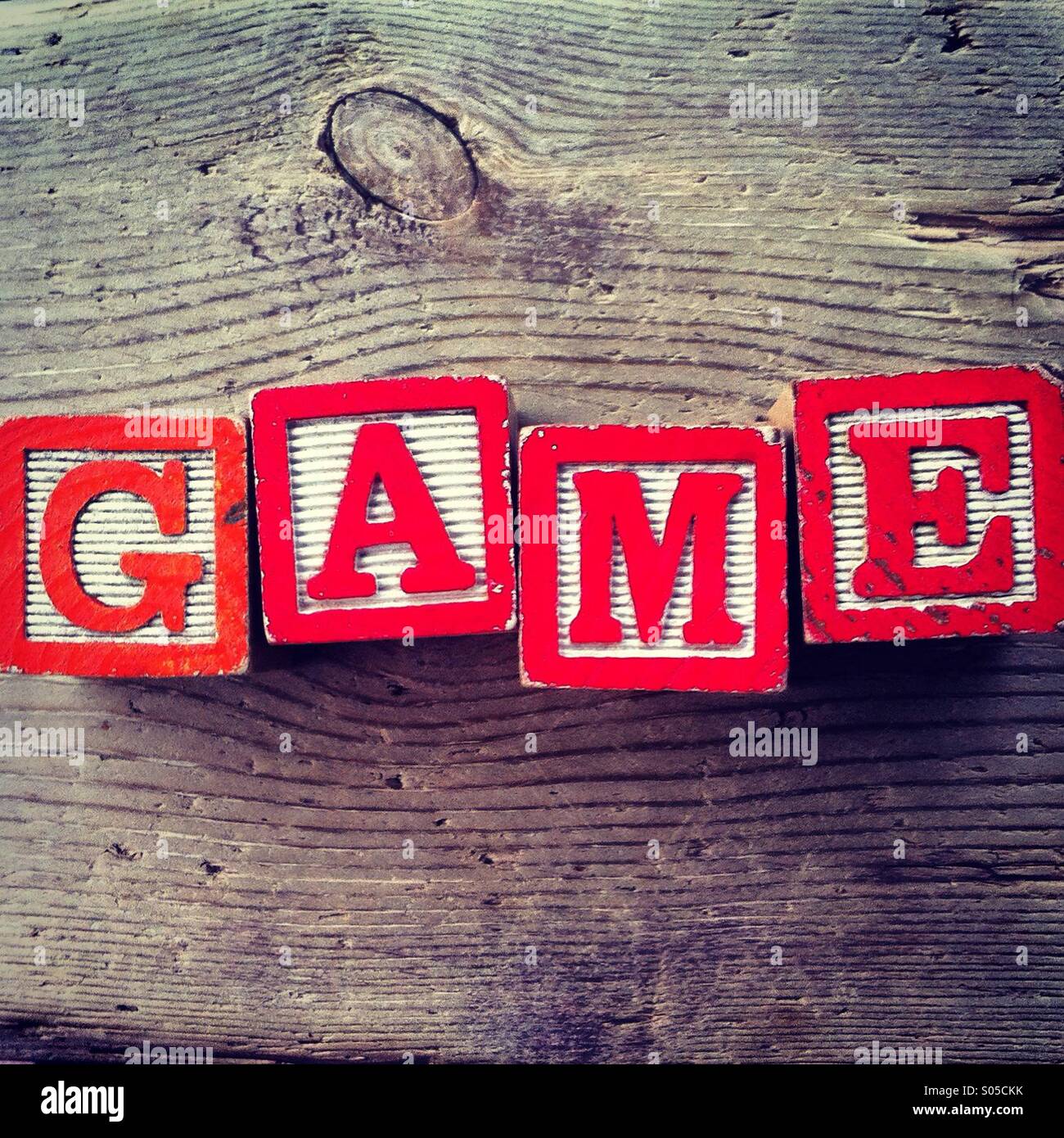 It's a photo of few wood blocks with colored letters on them that are combined together to create the word GAME - Smartphone Captured Stock Image