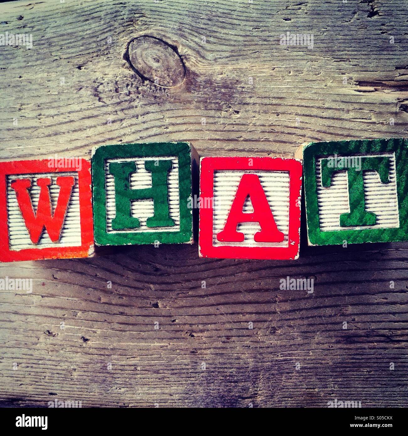 It's a photo of few wood blocks with colored letters on them that are combined together to create the word WHAT - Smartphone Captured Stock Image