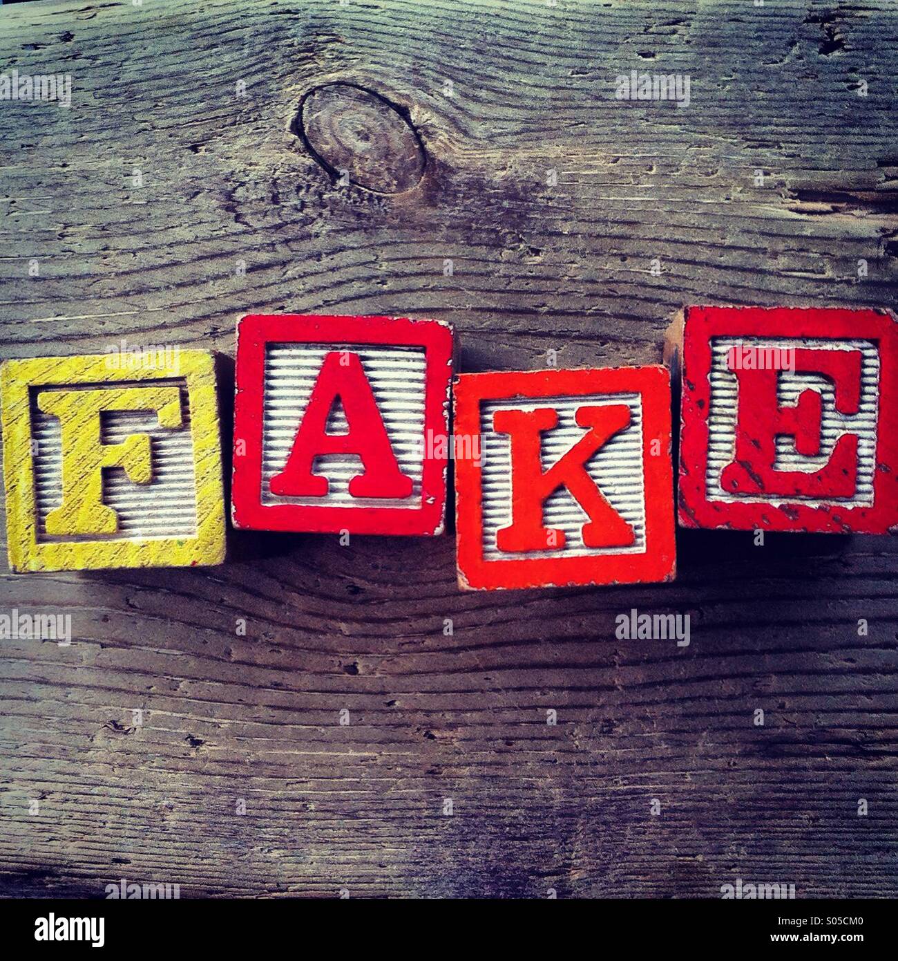 It's a photo of few wood blocks with colored letters on them that are combined together to create the word FAKE Stock Photo