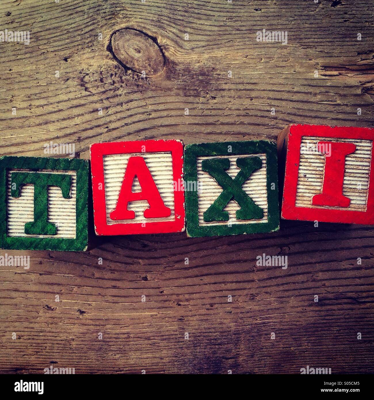 It's a photo of few wood blocks with colored letters on them that are combined together to create the word TAXI - Smartphone Captured Stock Image