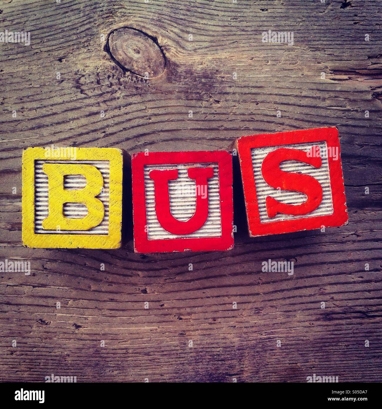 It's a photo of few wood blocks toys with alphabet letters on them combined together to create the word BUS - Smartphone Captured Stock Image