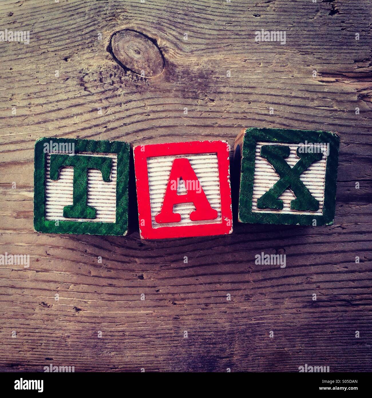 It's a photo of few wood blocks toys with alphabet letters on them combined together to create the word TAX Stock Photo