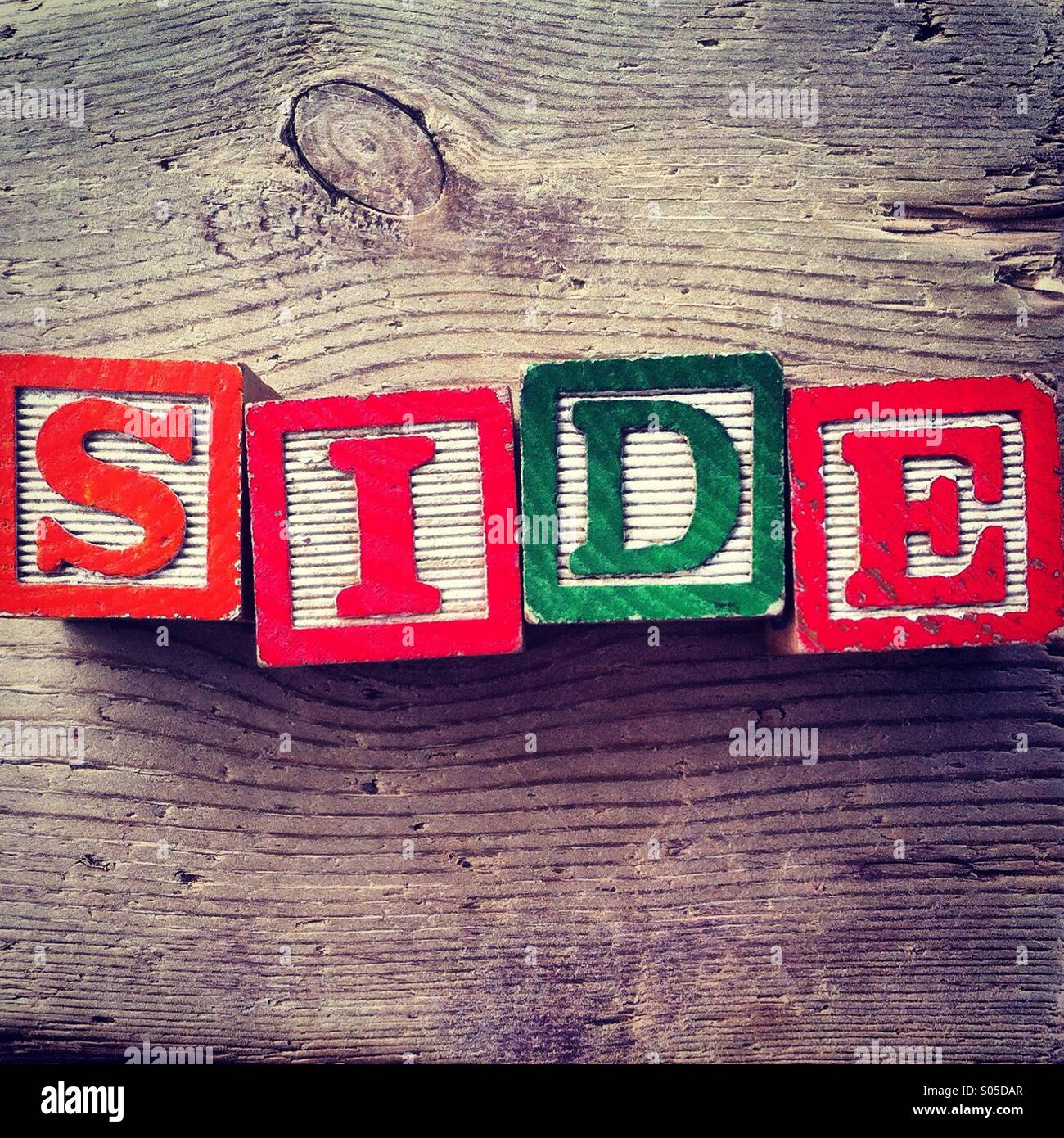 It's a photo of few wood blocks toys with alphabet letters on them combined together to create the word SIDE - Smartphone Captured Stock Image