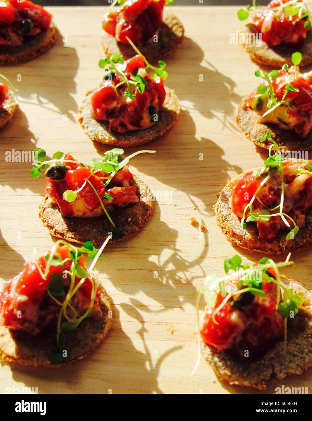 Snack's or Appetisers carpaccio of beef with herbs on toasties. Served with drinks in the sunshine Stock Photo