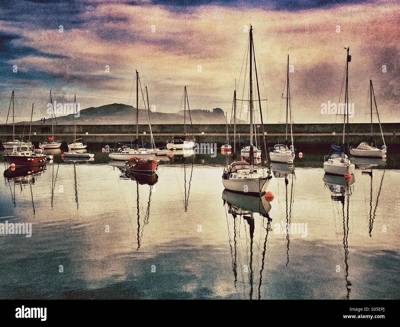 Yachts moored in harbour with Island in background Stock Photo
