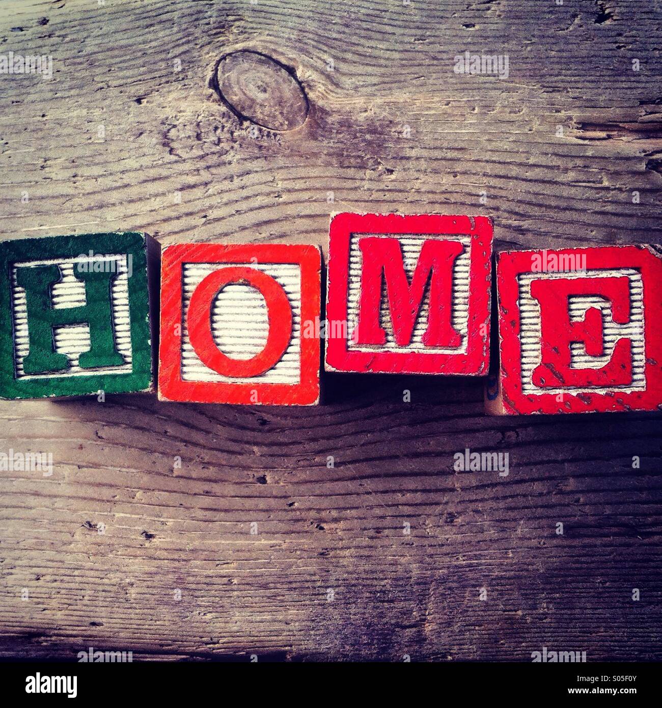 It's a photo of few wood blocks with letter on them that are combined together to create the word HOME Stock Photo