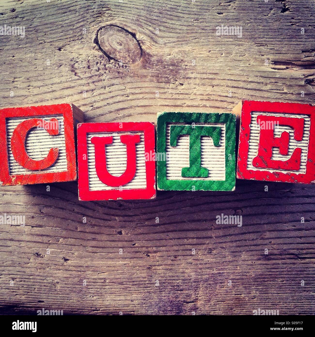 It's a photo of few wood blocks with letter on them that are combined together to create the word CUTE - Smartphone Captured Stock Image