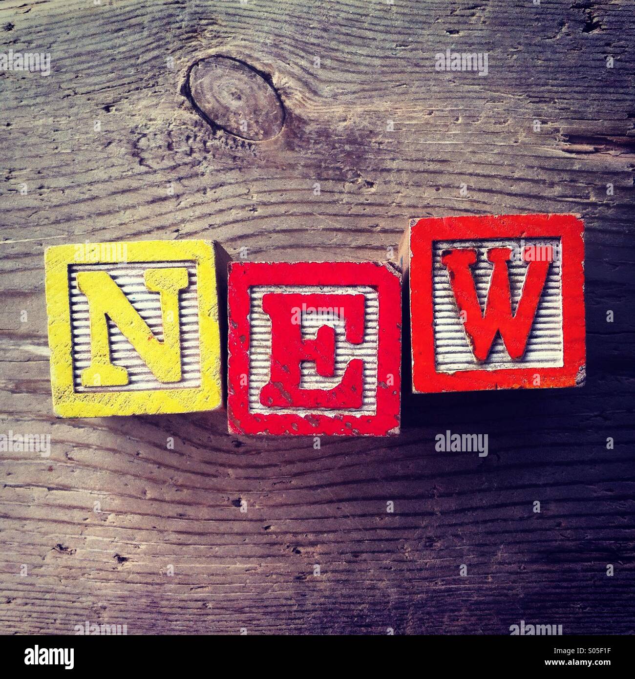 It's a photo of few wood blocks with letter on them that are combined together to create the word NEW - Smartphone Captured Stock Image