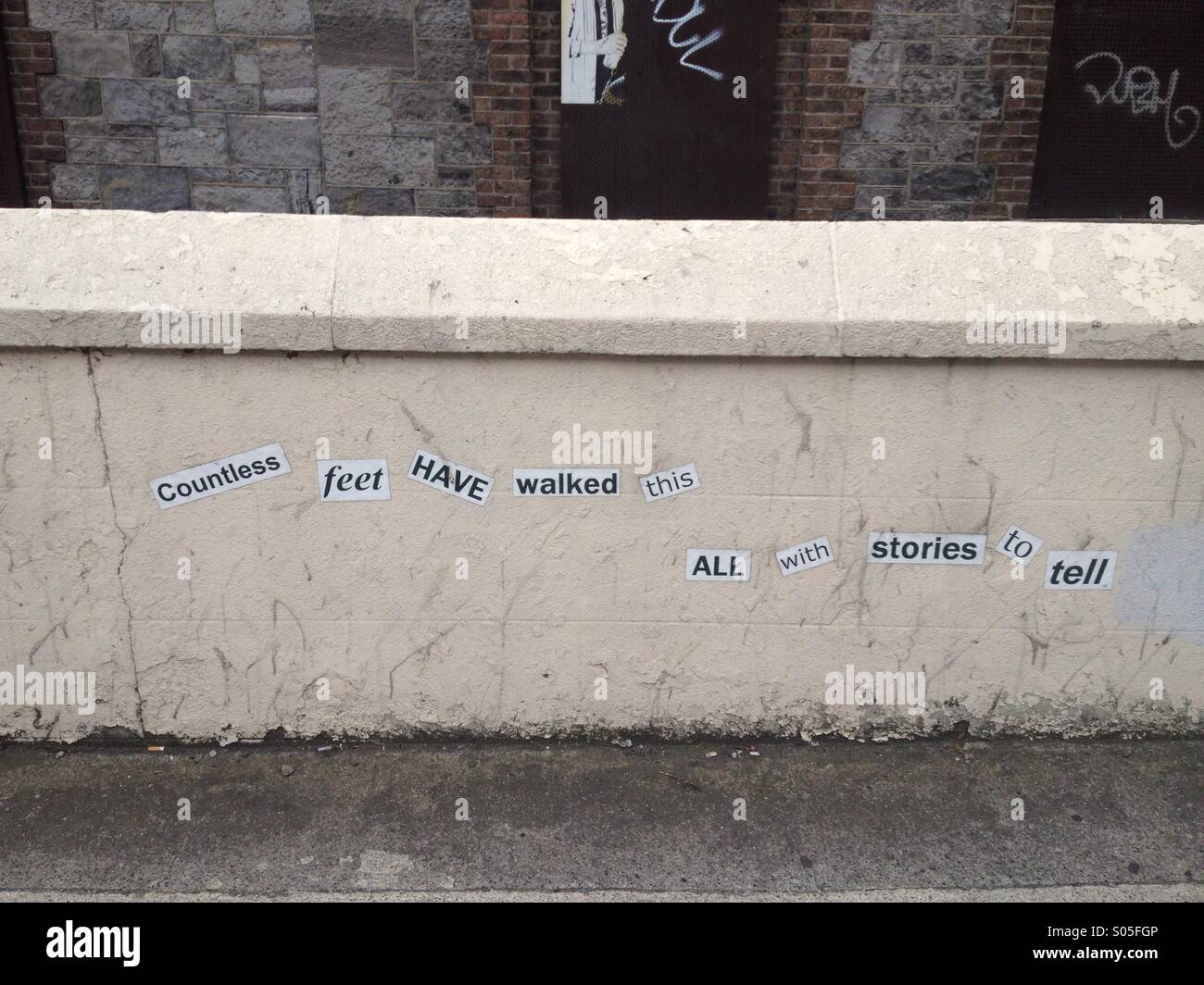 Street art on a wall in Dublin city, Ireland reading 'Countless feet have walked this all with stories to tell' Stock Photo