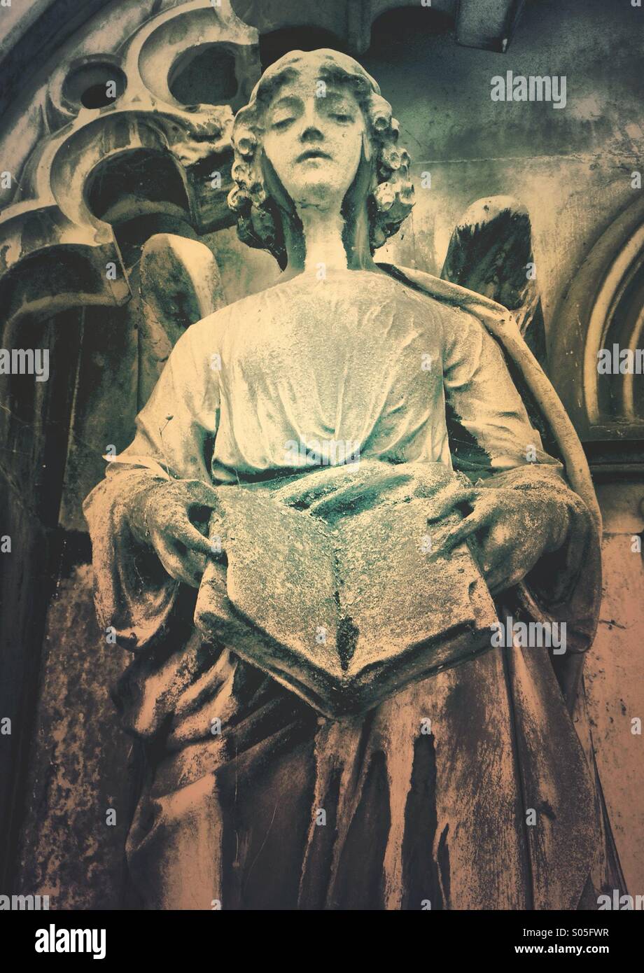 Figure of an Angel holding the Bible on a mausoleum in Brompton Cemetery, London Stock Photo