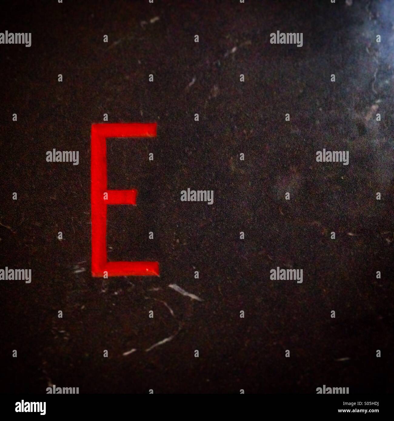 A red letter E decorates a black wall in Queretaro, Mexico - Smartphone Captured Stock Image