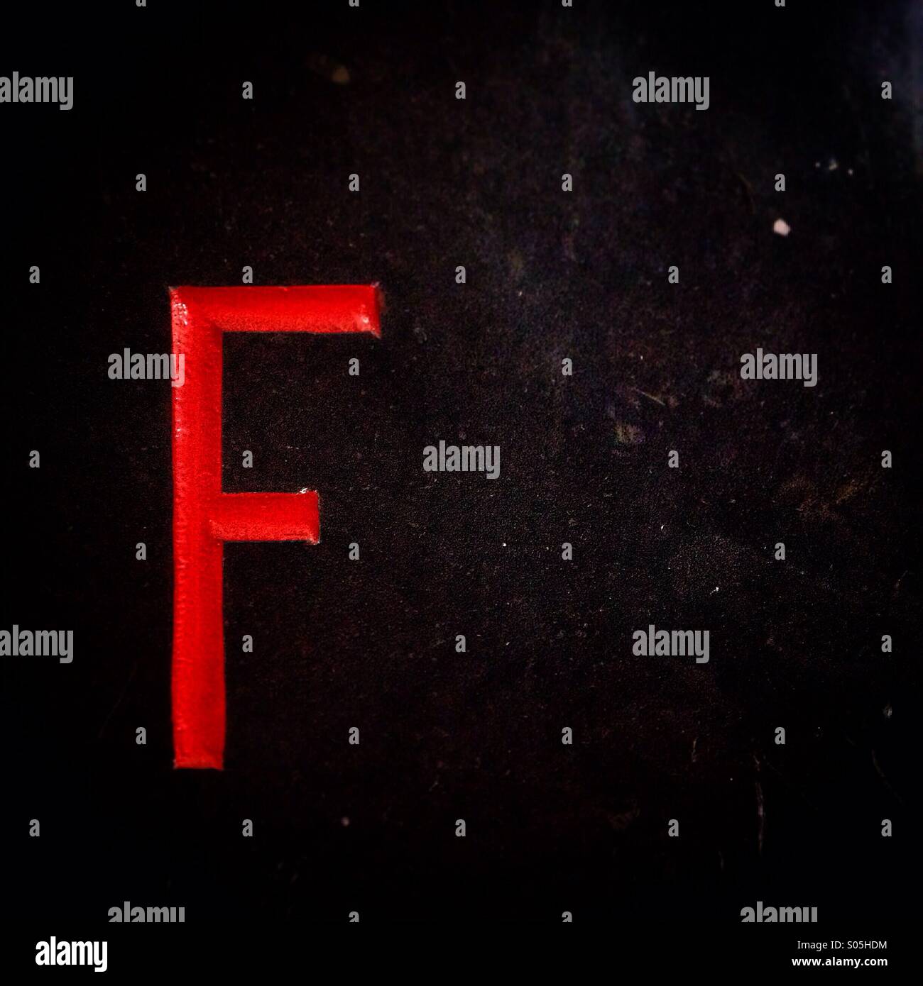 A letter 'f' decorates a black wall in Queretaro, Mexico - Smartphone Captured Stock Image