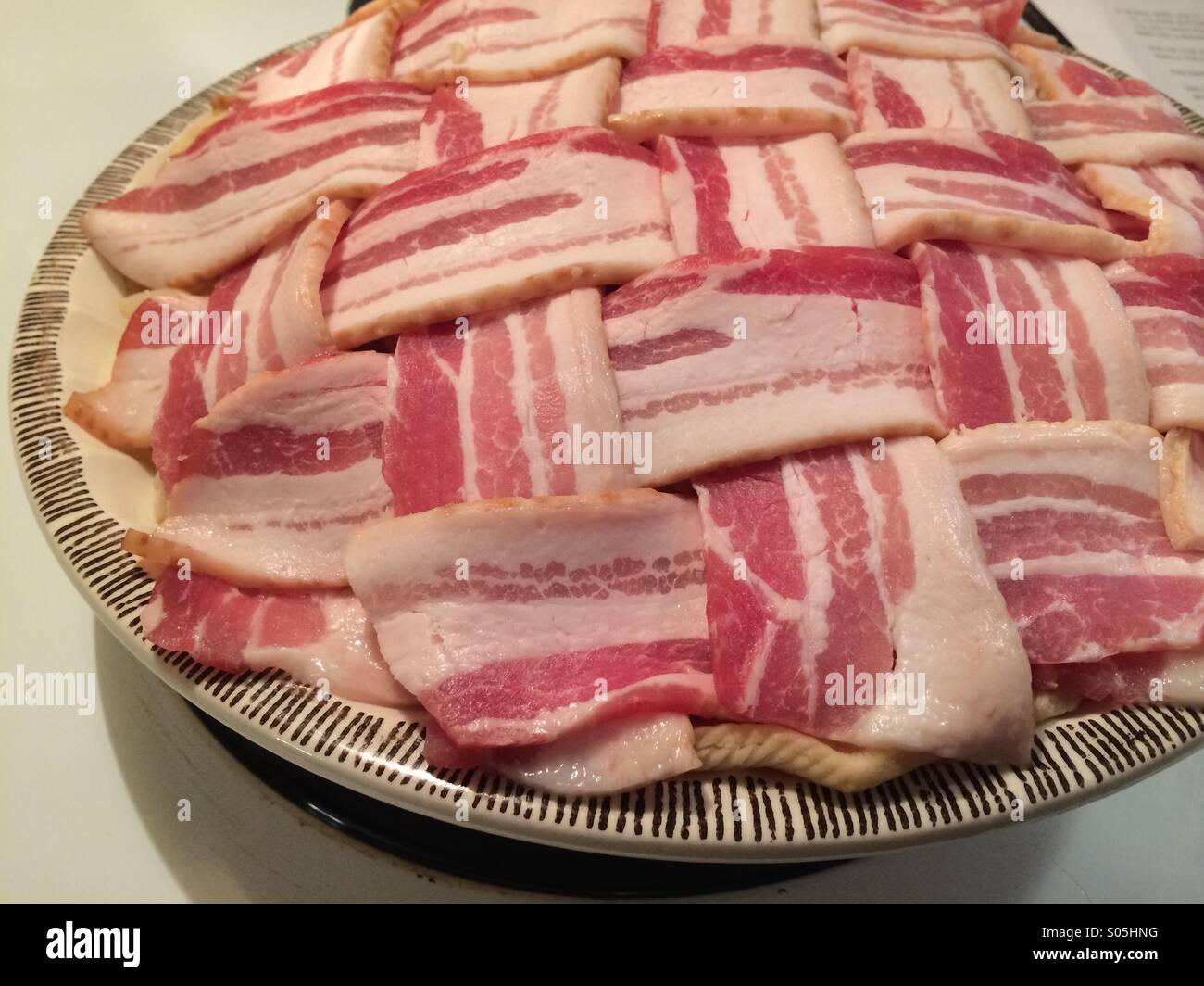 A pie covered with raw bacon Stock Photo