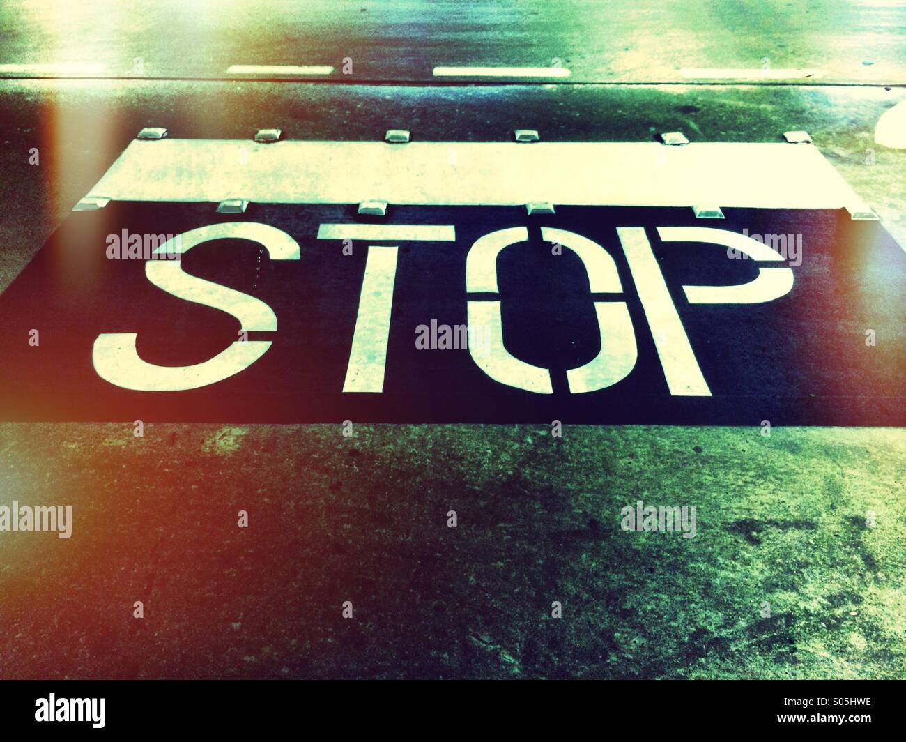 Stop painted on a road in a parking lot. Stock Photo