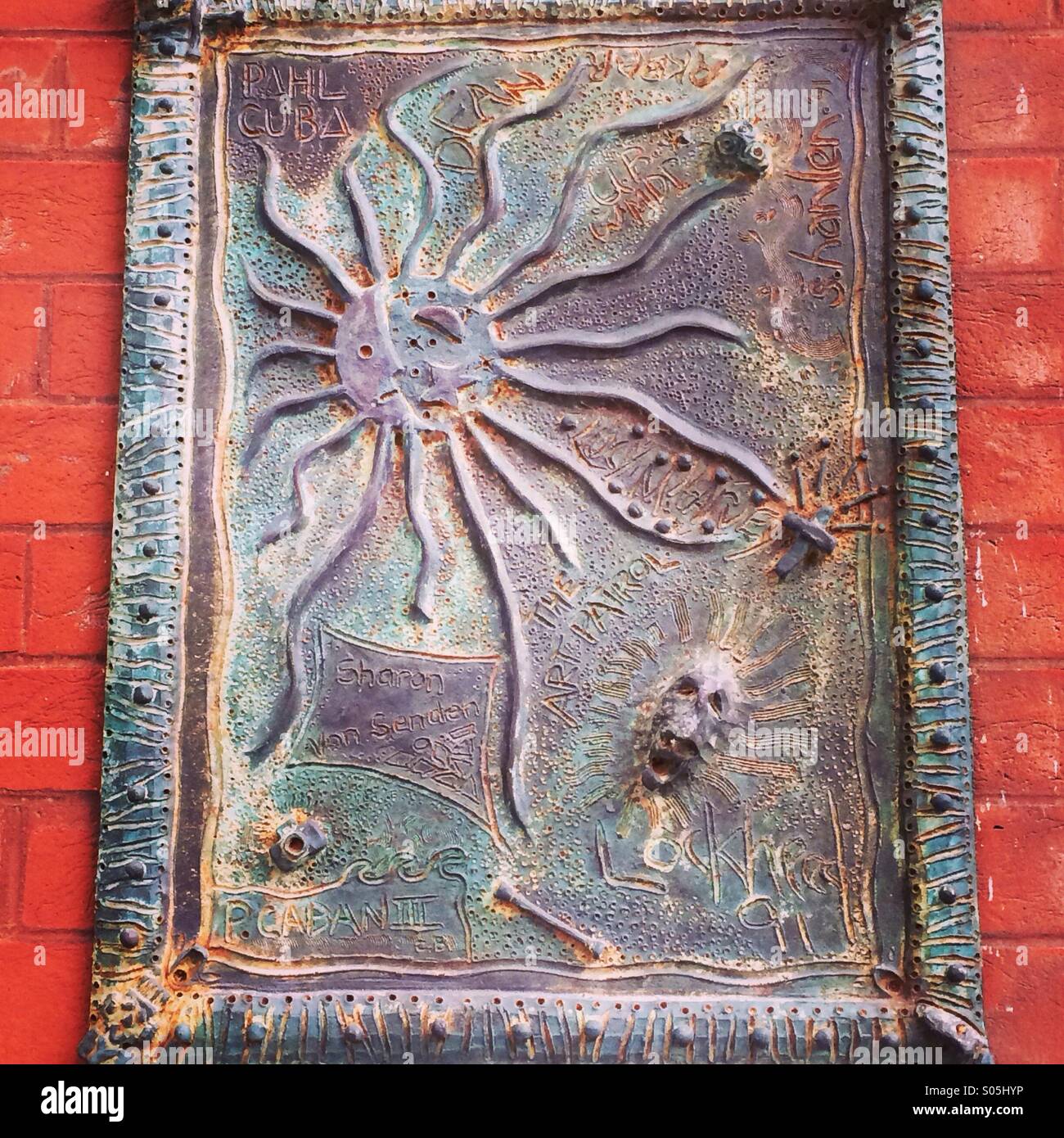 Ceramic sun art on brick wall - Smartphone Captured Stock Image