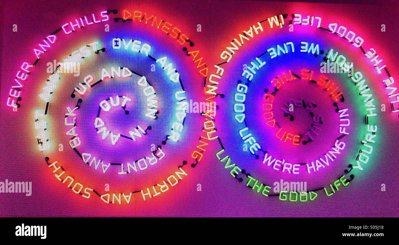 A neon artwork featuring various sayings in bright colored lights Stock