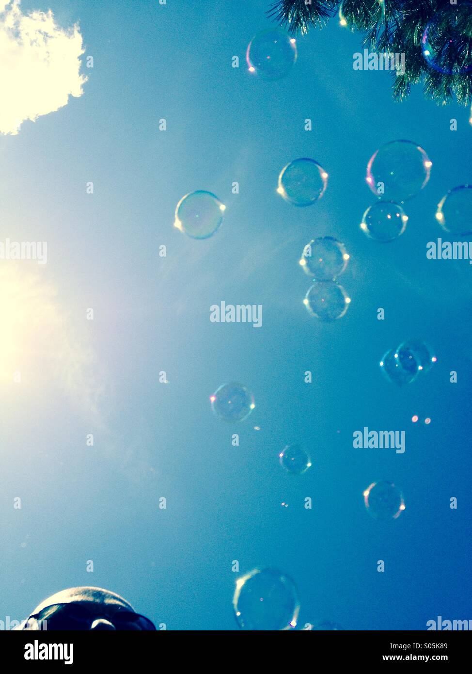 Man watching bubbles rising towards the sky - Smartphone Captured Stock Image