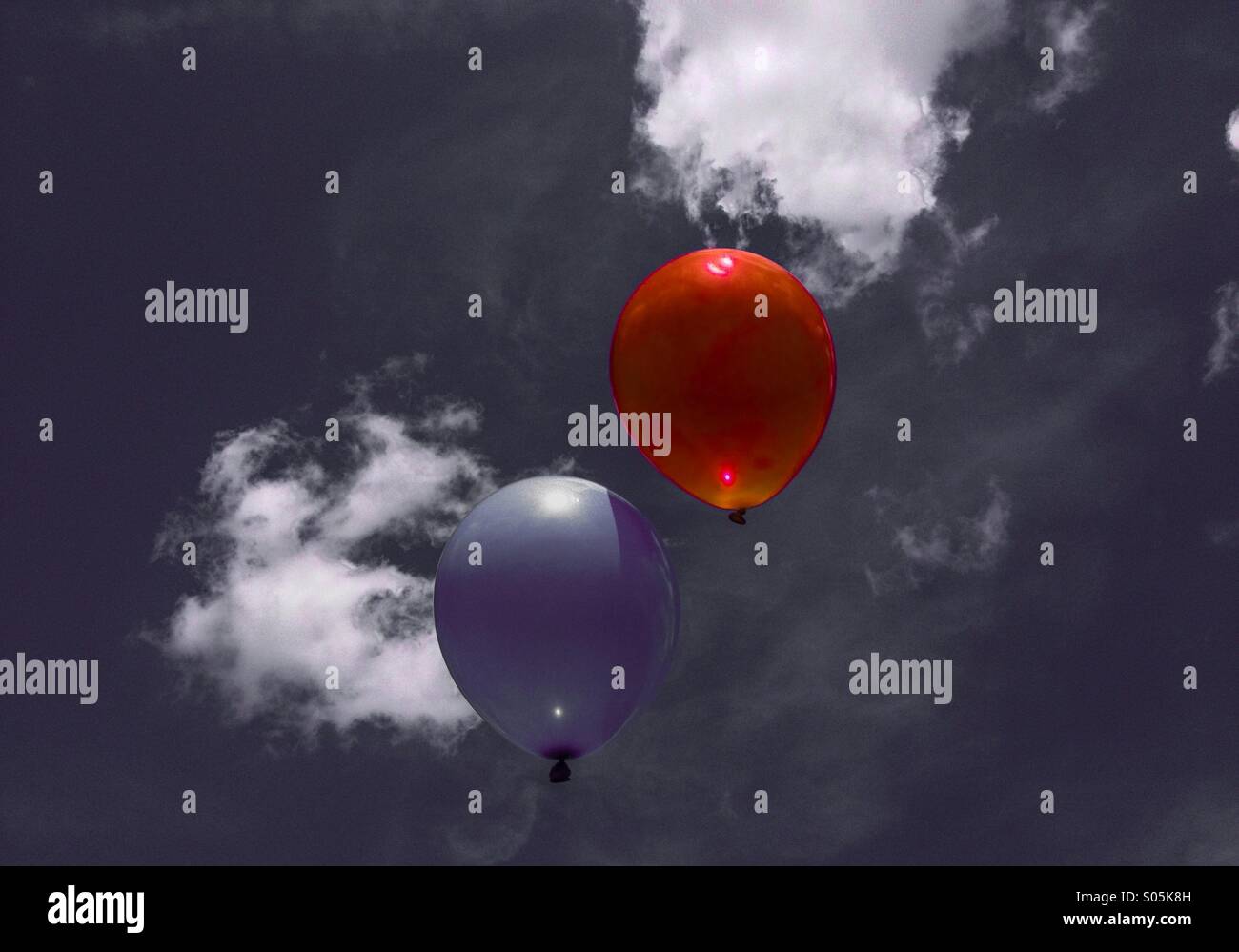 Blue and red balloons floating in a monochrome sky - Smartphone Captured Stock Image