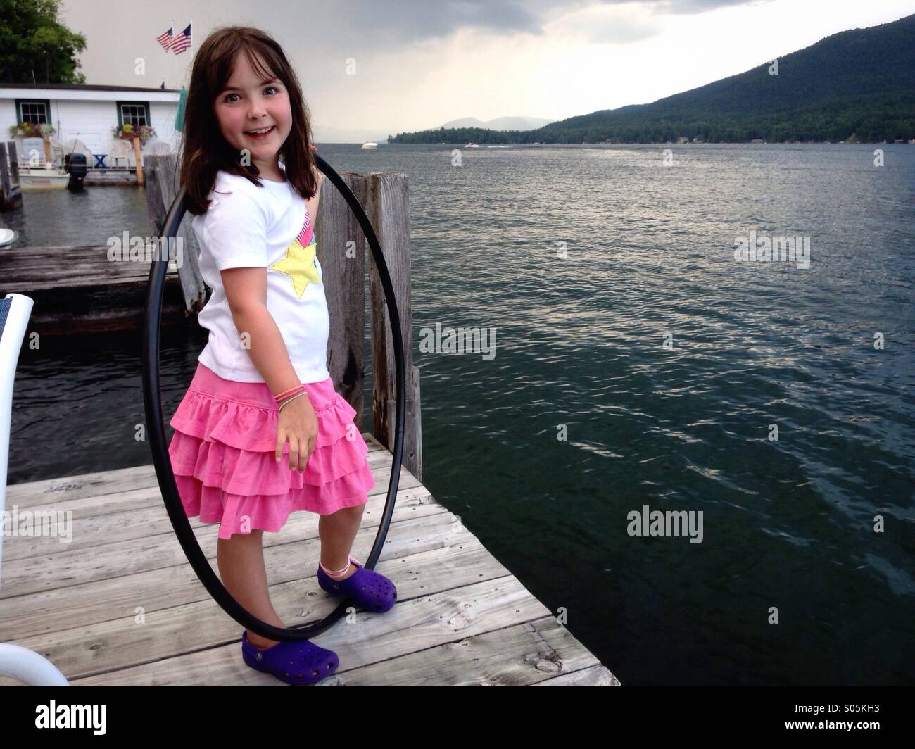 Young girl on dock with hula hoop Stock Photo