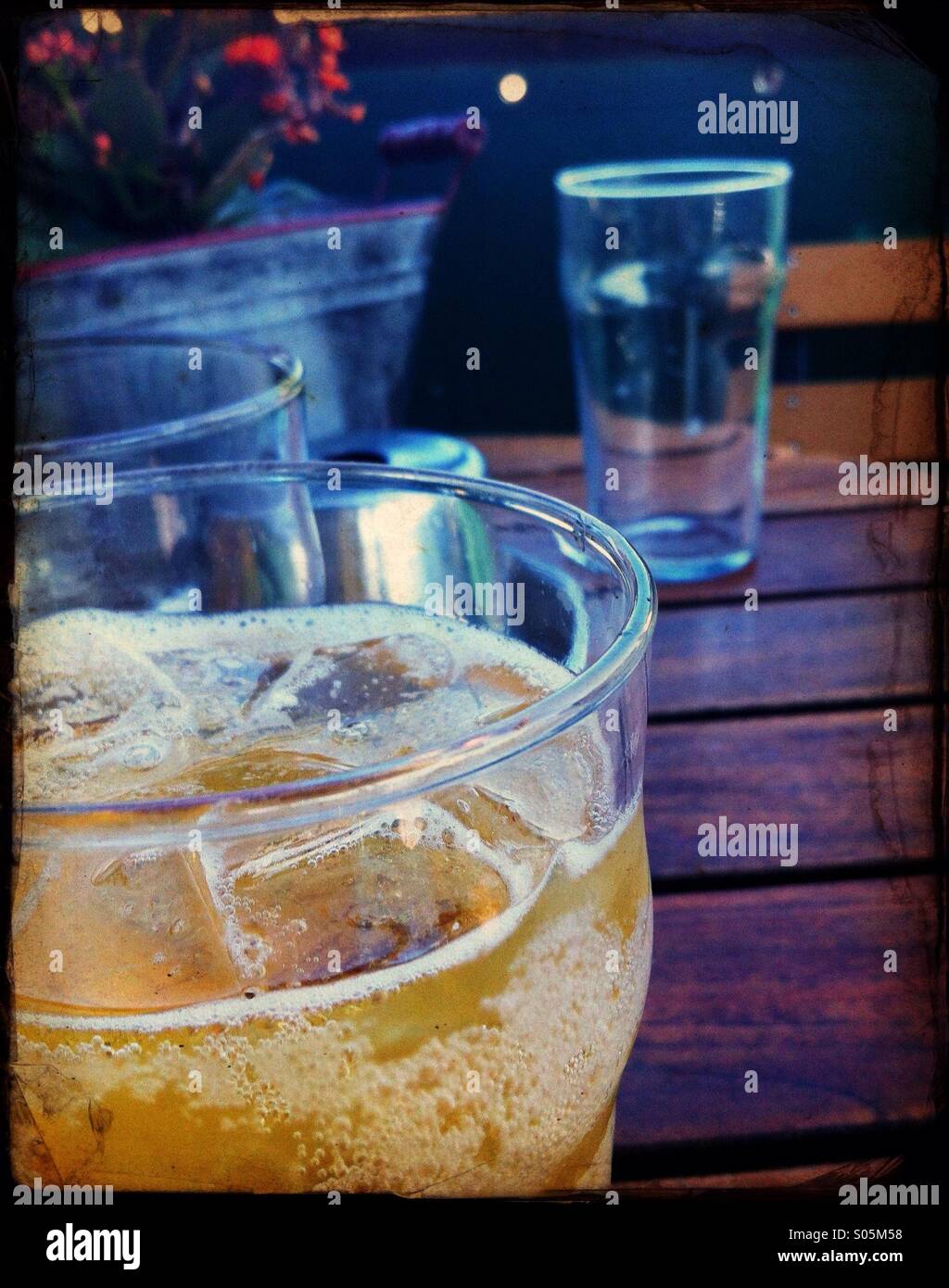 A Bar table with a full glass of cider and an empty glass Stock Photo