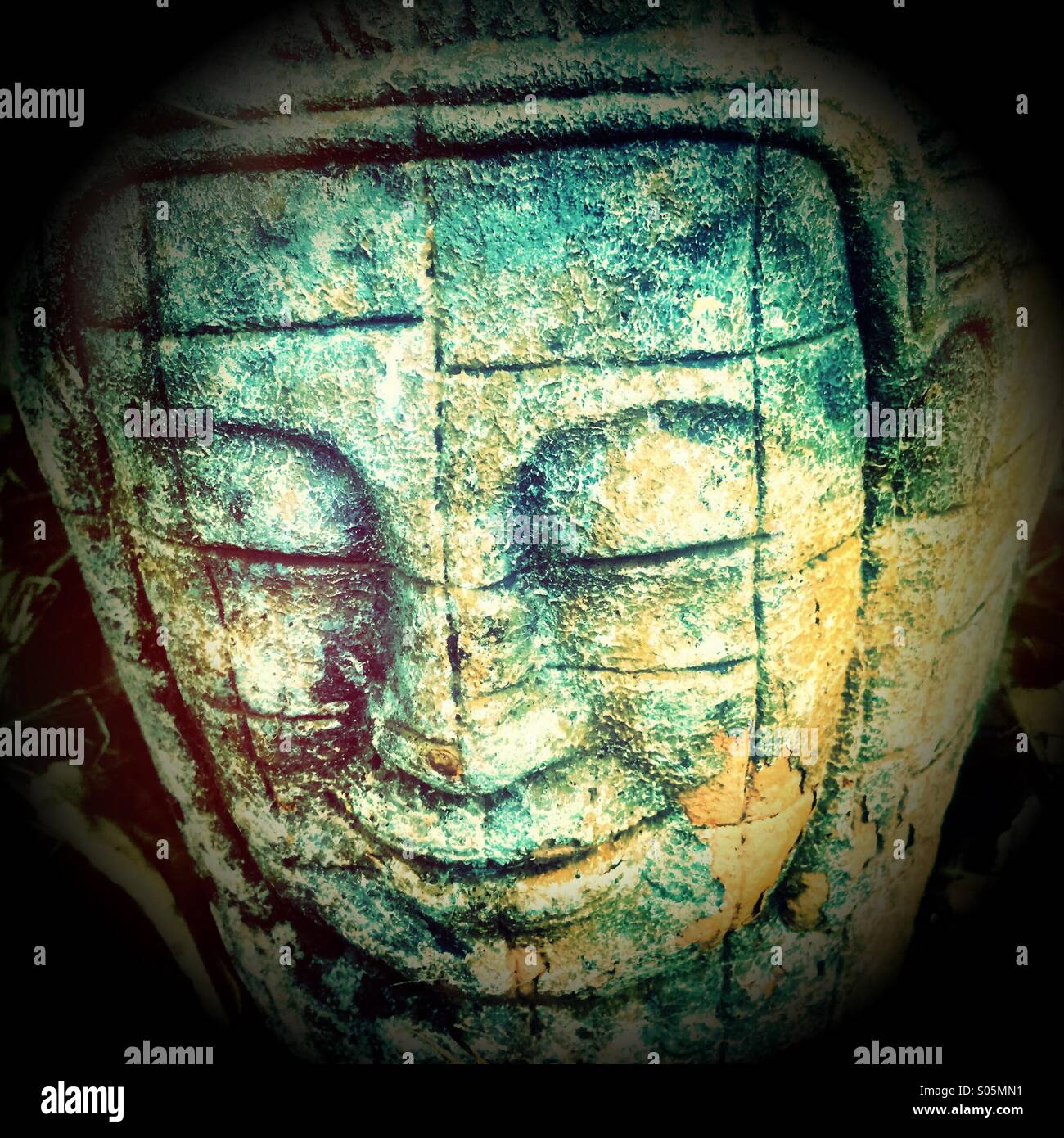 Buddha face on a flowerpot. Stock Photo