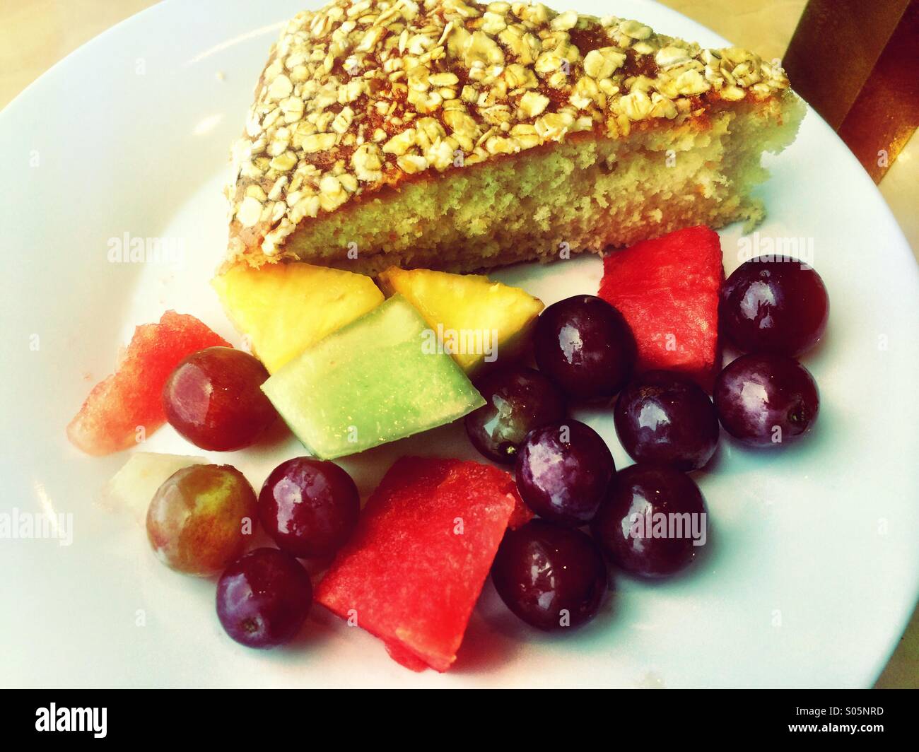 Slice of cake and fresh fruit pieces on plate. Stock Photo