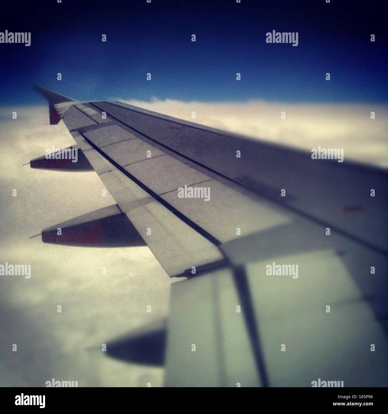View of a plane wing during a flight above the clouds Stock Photo - Alamy