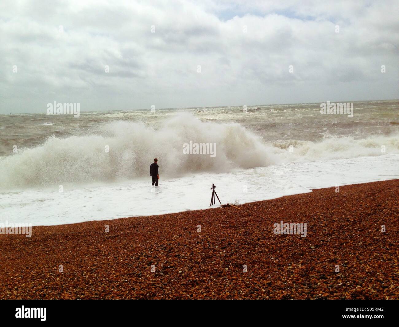 Photographer films himself in storm waves on Brighton Beach Stock Photo