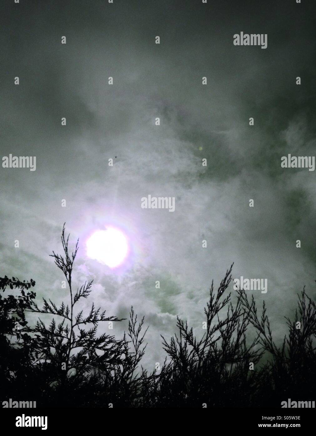 Sun shining through clouds Stock Photo - Alamy