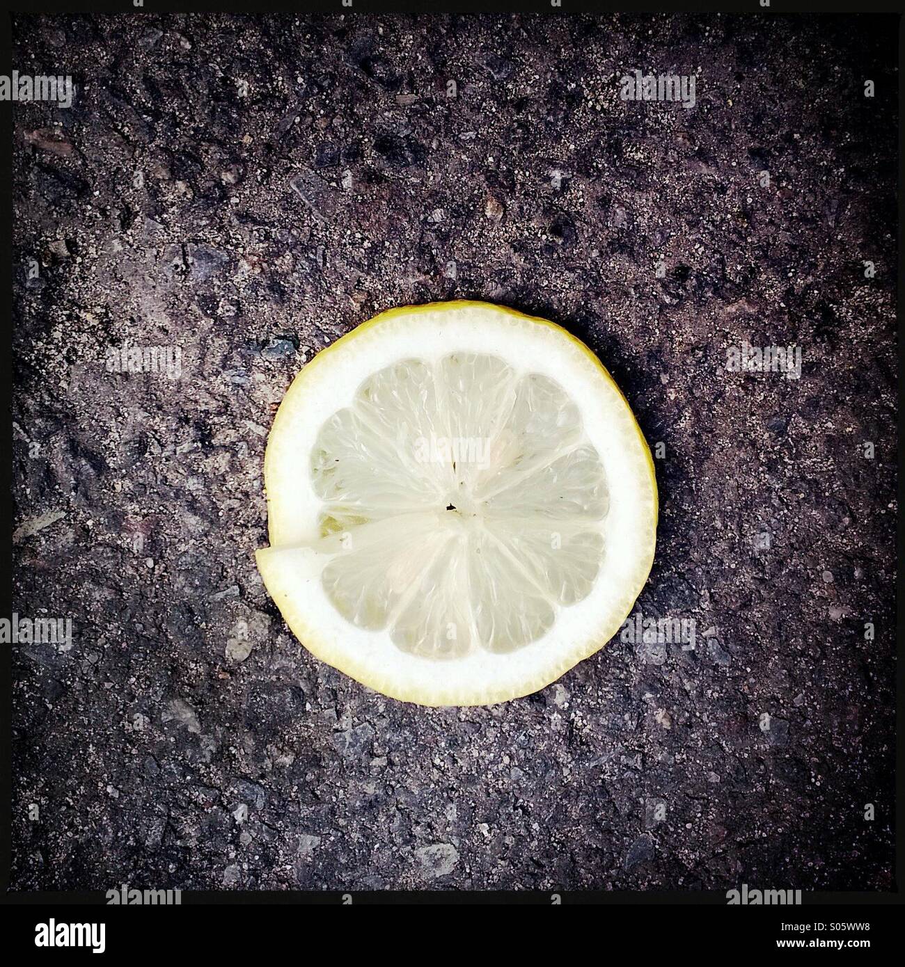 Lemon slice over black macadam Stock Photo