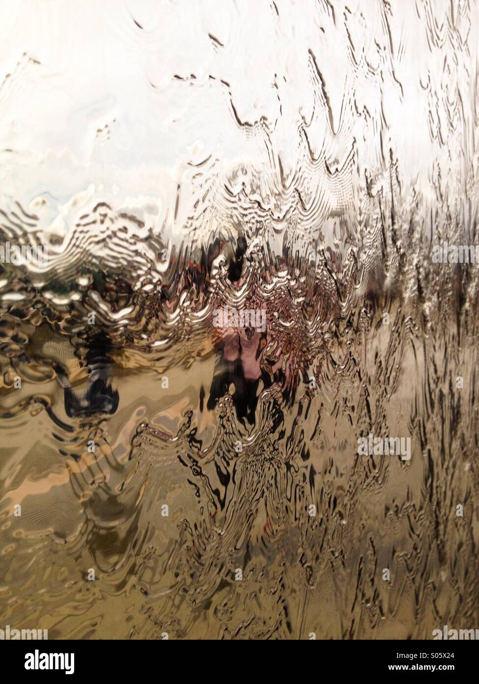 Water flows down a sheet of metal - Smartphone Captured Stock Image