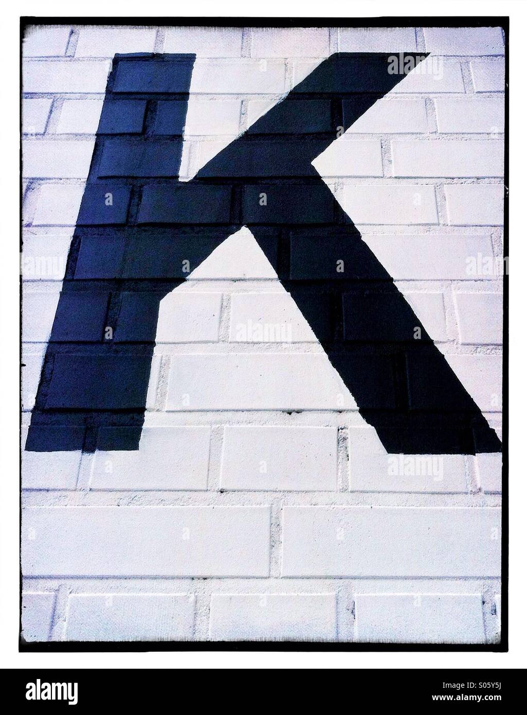 Letter 'K' painted on brick wall Stock Photo