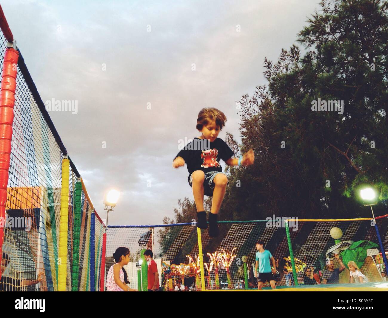 Five years old boy jumping over a trampoline Stock Photo