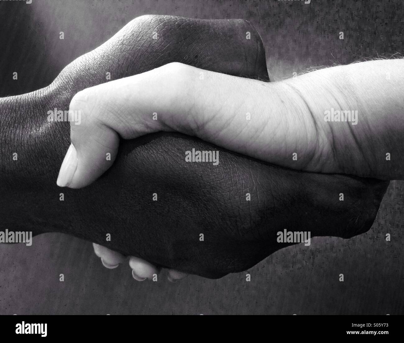 Black hand and white hand shake - Smartphone Captured Stock Image