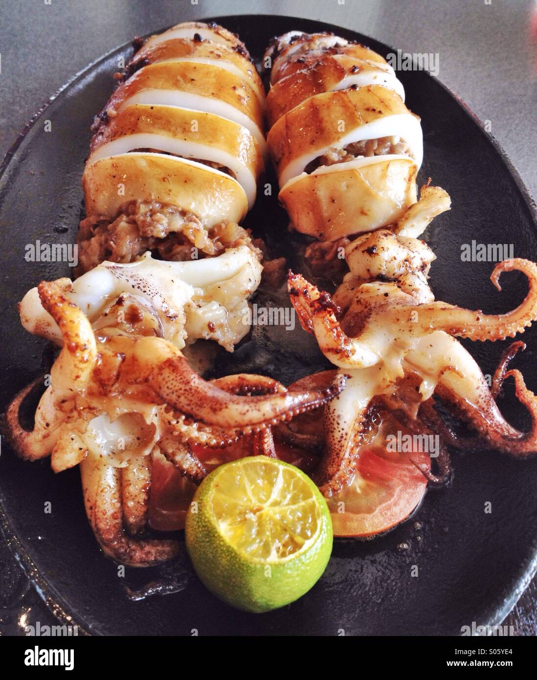 Filipino dish of stuffed squid on a sizzling plate Stock Photo