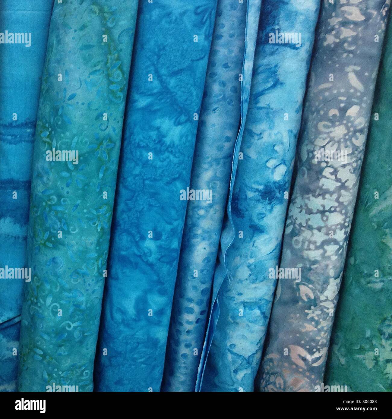 Blue and turquoise batik fabrics (cloth) on bolts Stock Photo