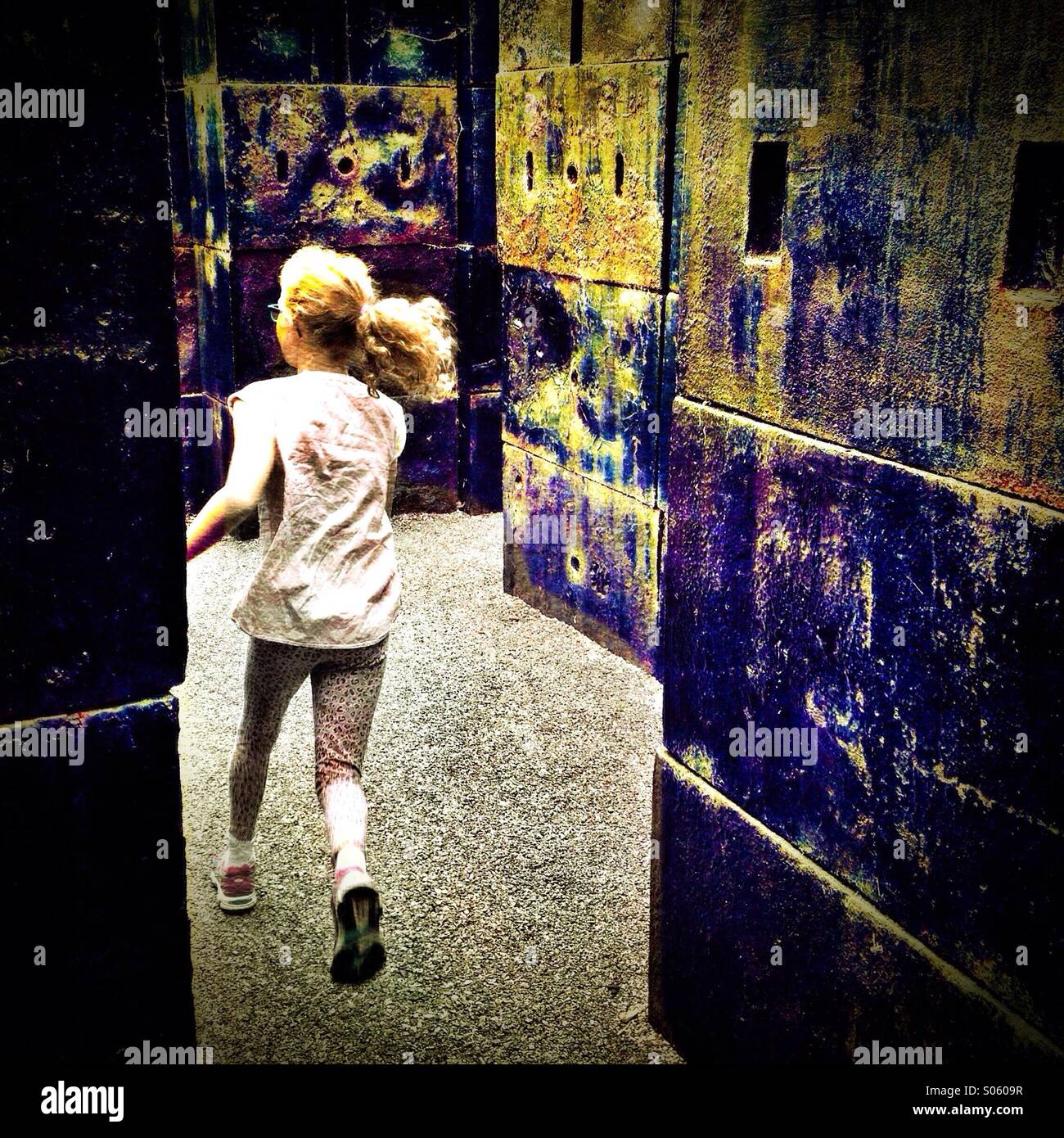 Girl running through maze of concrete blocks Stock Photo Alamy