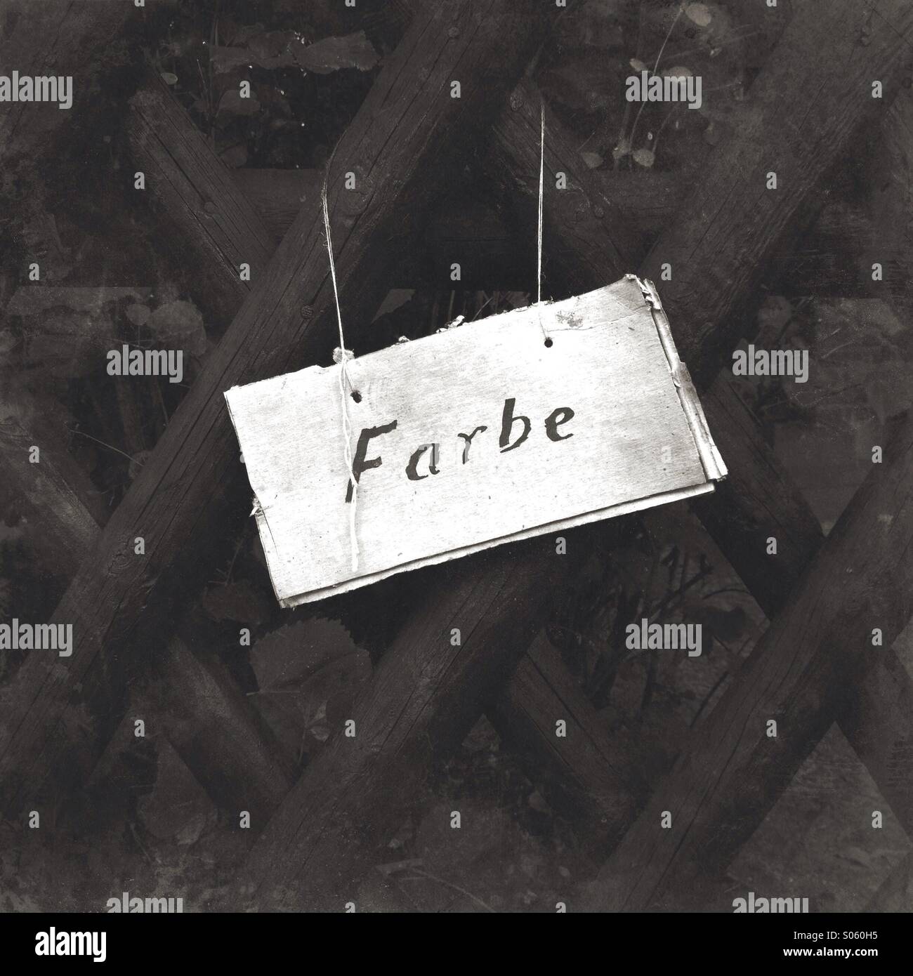'Farbe' (color) sign written in German on a black fence, warning of fresh paint. Stock Photo