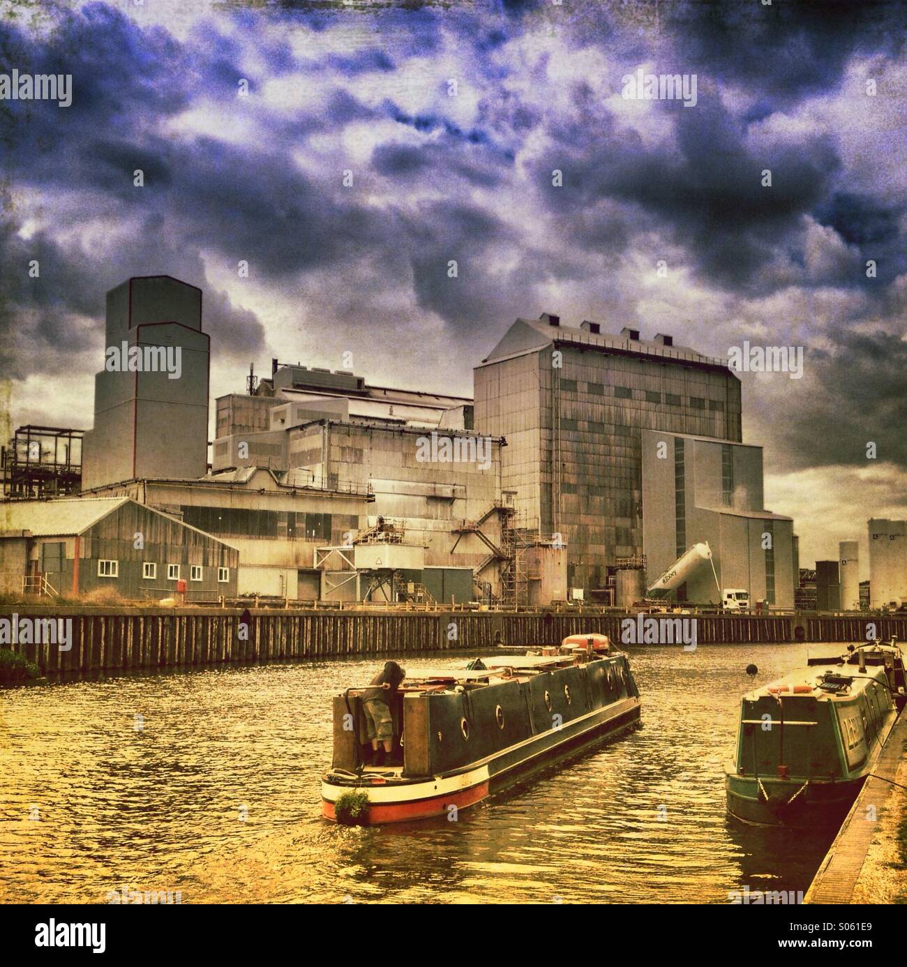 Narrow boats in front of industrial scene on river weaver - Smartphone Captured Stock Image