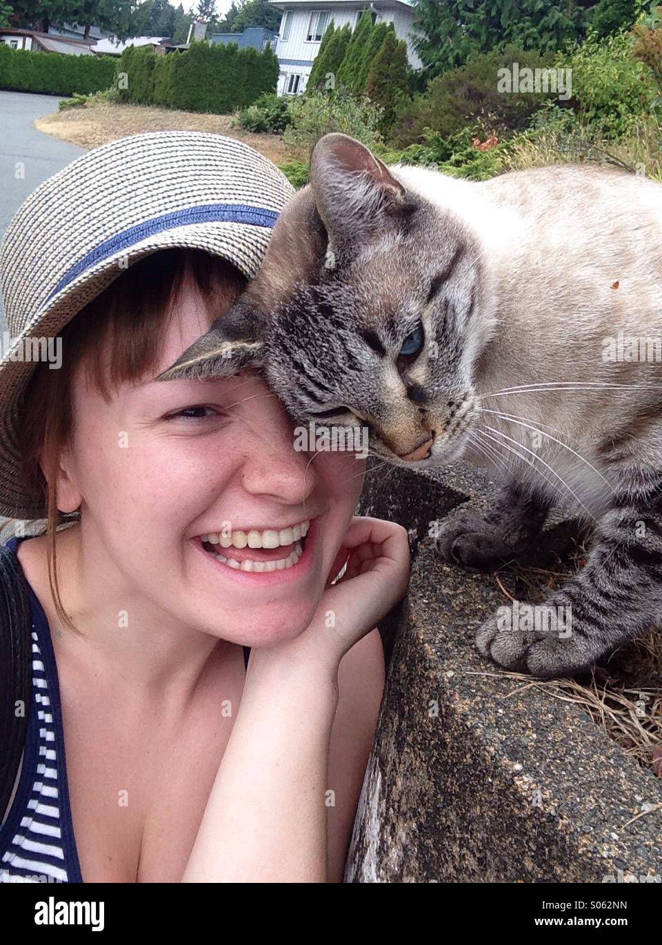 Cat rubs up against girl showing affection Stock Photo Alamy