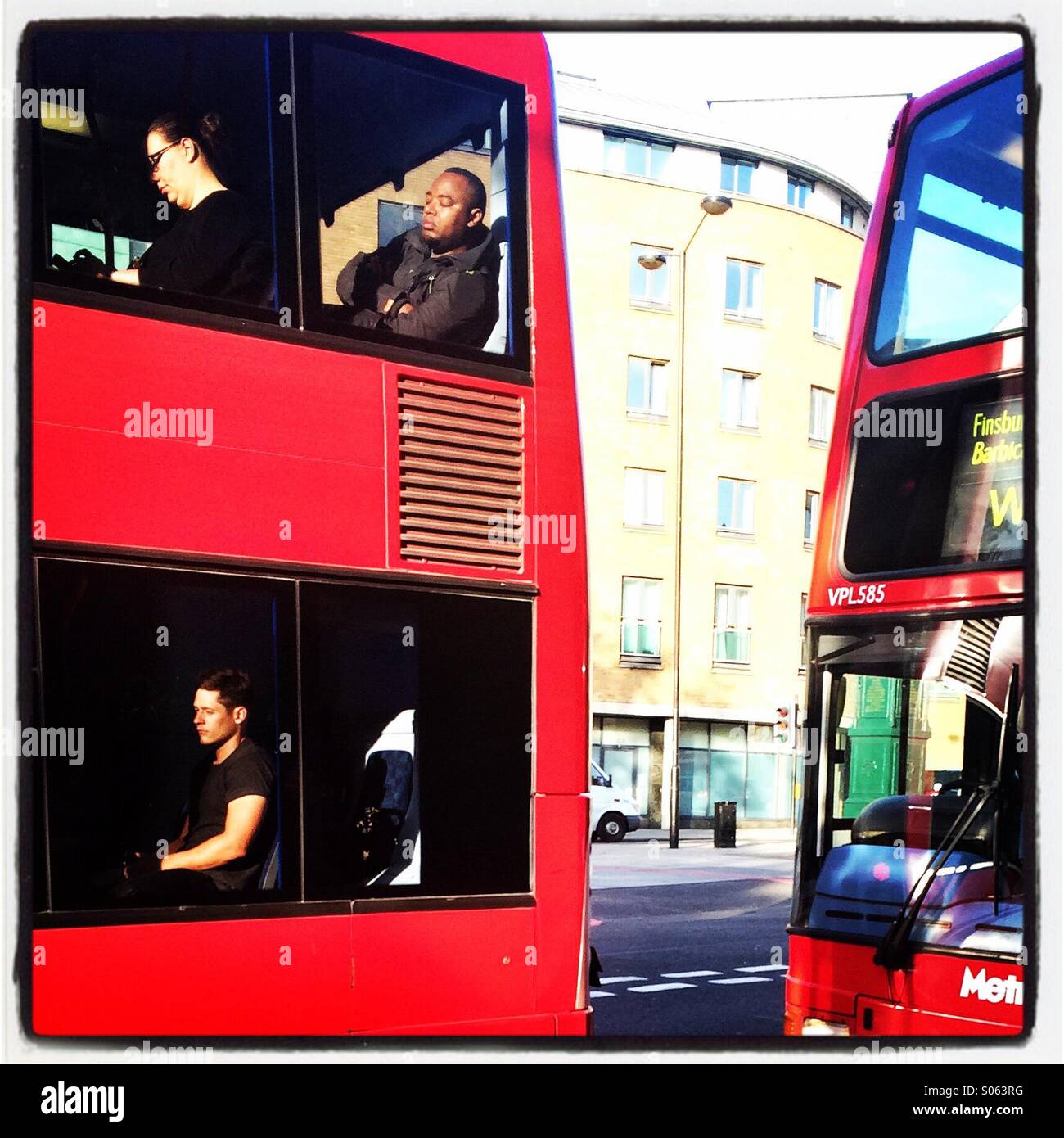 People sleeping on a London bus. Stock Photo