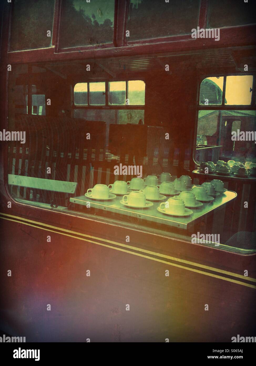 Cups and saucers set up in a vintage train carriage Stock Photo