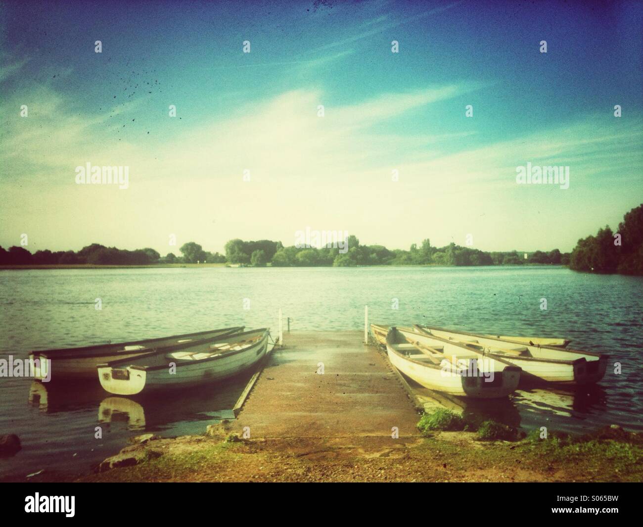 Moored rowing boats used for fishing. Grunge effect applied. - Smartphone Captured Stock Image
