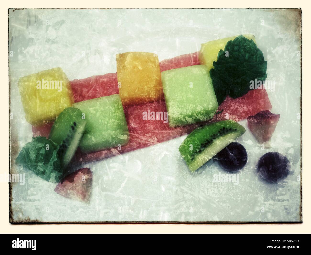 Cut up fruit on a plate with a mint leaf Stock Photo Alamy