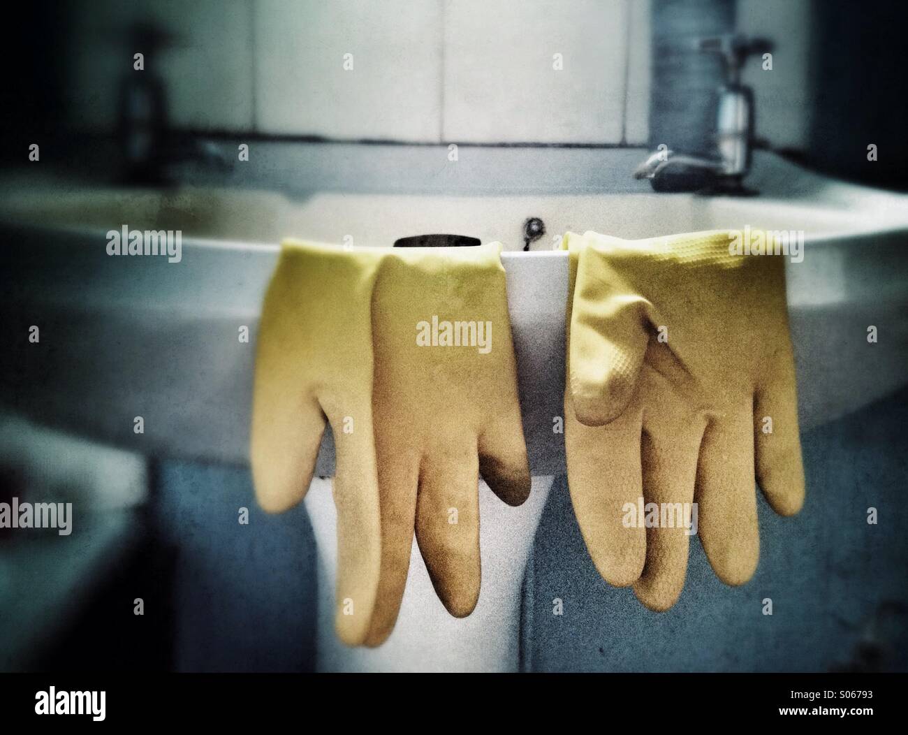 Rubber gloves on a bathroom sink Stock Photo