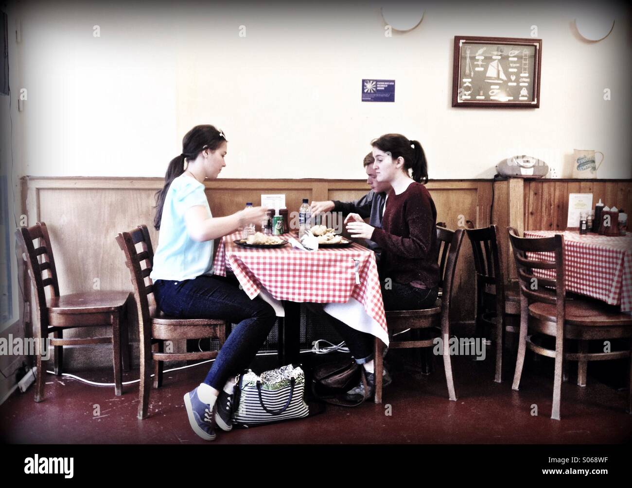 Young people eating fish and chips in cafe - Smartphone Captured Stock Image