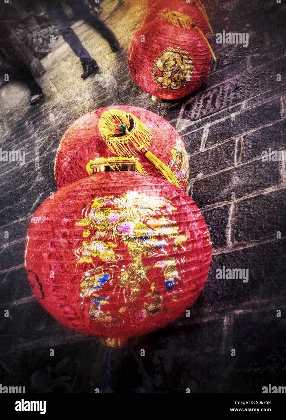 Chinese lanterns on the pavement as people walk by in Chinatown, London, England, UK - Smartphone Captured Stock Image