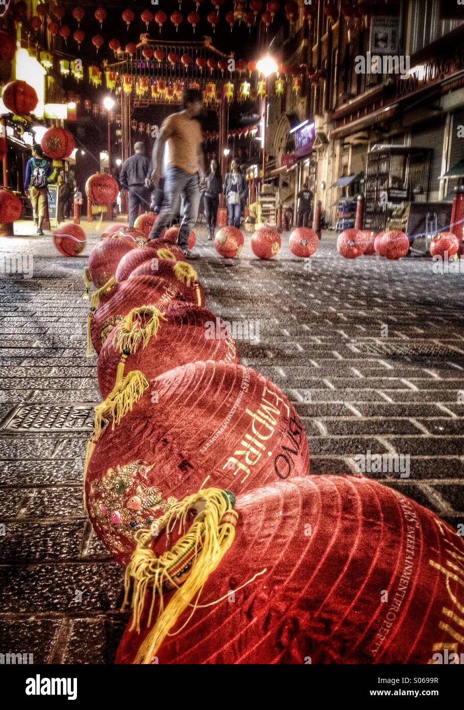 Man prepares paper lanterns for hanging across Gerrard Street in London's Chinatown - Smartphone Captured Stock Image