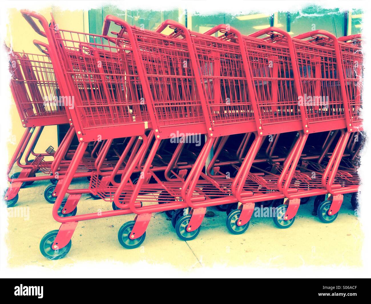 A row of red shopping trolleys. - Smartphone Captured Stock Image